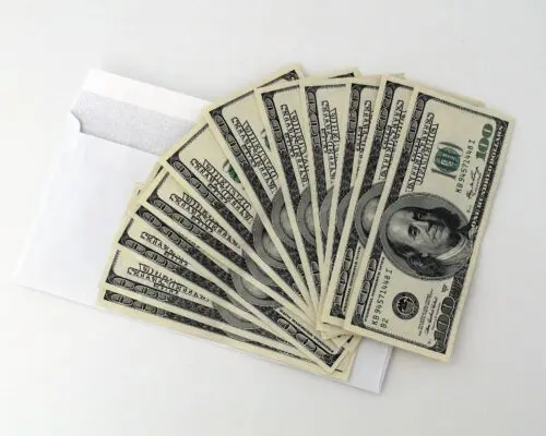 Cash pulled from a white envelope.