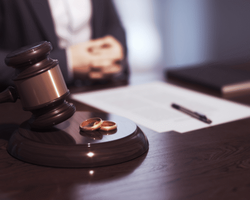 Judge’s gavel beside two wedding rings on a courtroom desk with legal documents, symbolizing professional practice divorce protection PA. The image reflects business valuation divorce PA, lawyer practice division family law, and goodwill evaluation divorce PA in equitable distribution cases.